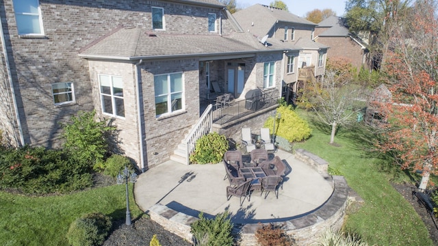 back of property featuring a patio area and a lawn