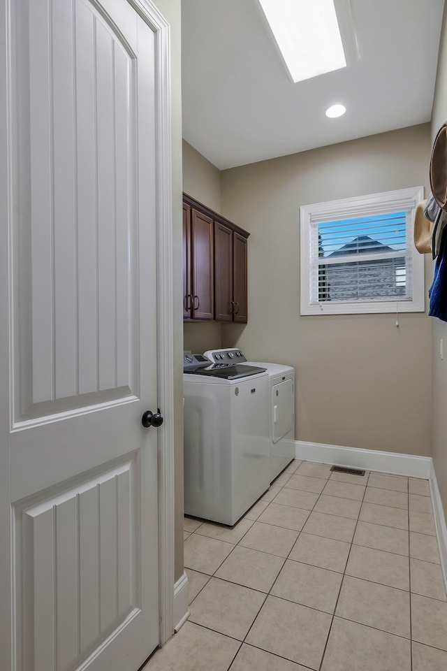 washroom with cabinets, independent washer and dryer, and light tile patterned flooring