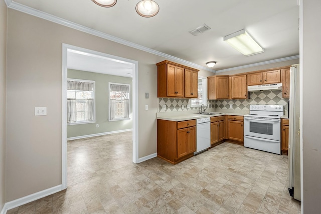 kitchen featuring white appliances, backsplash, crown molding, and sink