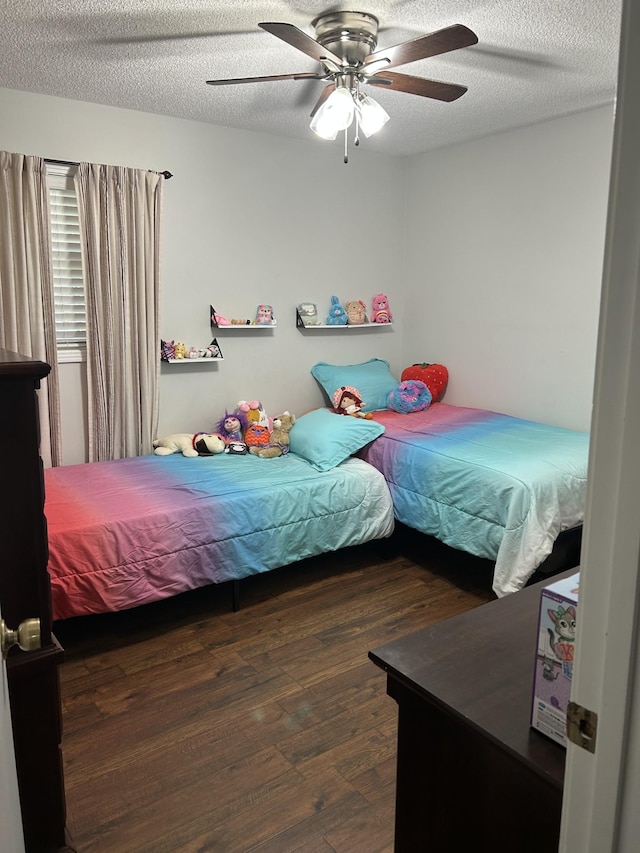 bedroom featuring a textured ceiling, ceiling fan, and dark wood-type flooring