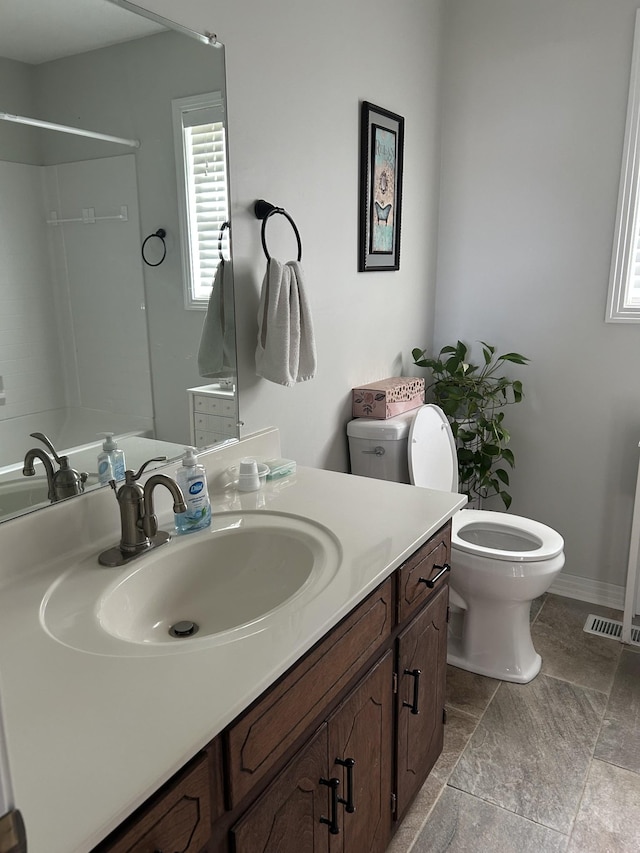 bathroom with a shower, vanity, and toilet