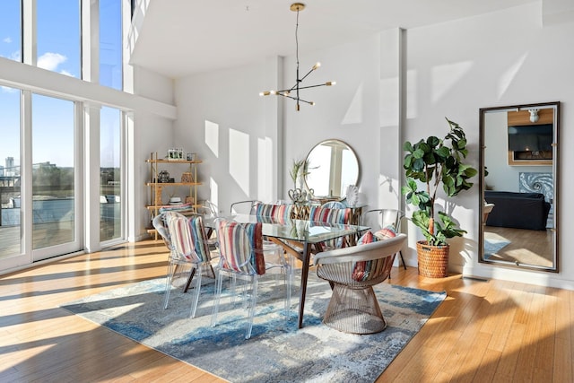 living room with hardwood / wood-style floors, a notable chandelier, and a towering ceiling