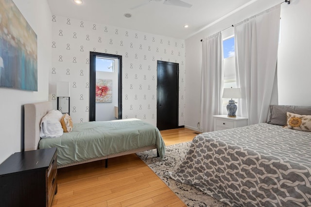 bedroom featuring multiple windows, light wood-type flooring, and ceiling fan