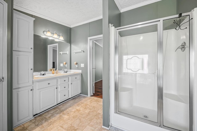 bathroom with vanity, ornamental molding, a textured ceiling, and walk in shower