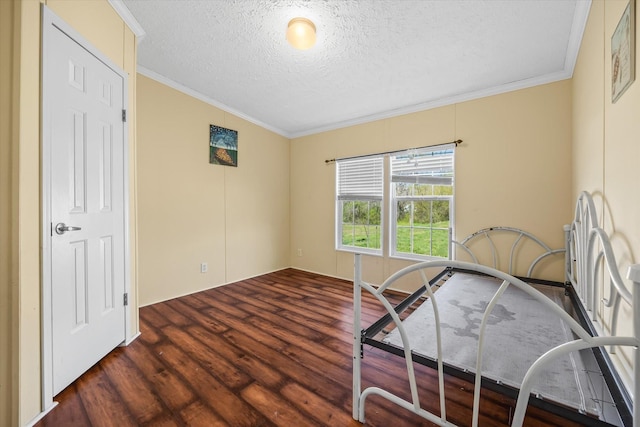 bedroom featuring dark wood-type flooring, a textured ceiling, and ornamental molding