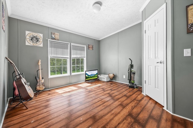 misc room featuring ornamental molding, a textured ceiling, and dark wood-type flooring