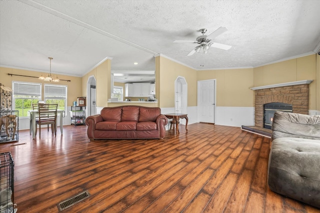 living room with a fireplace, crown molding, hardwood / wood-style floors, and a textured ceiling