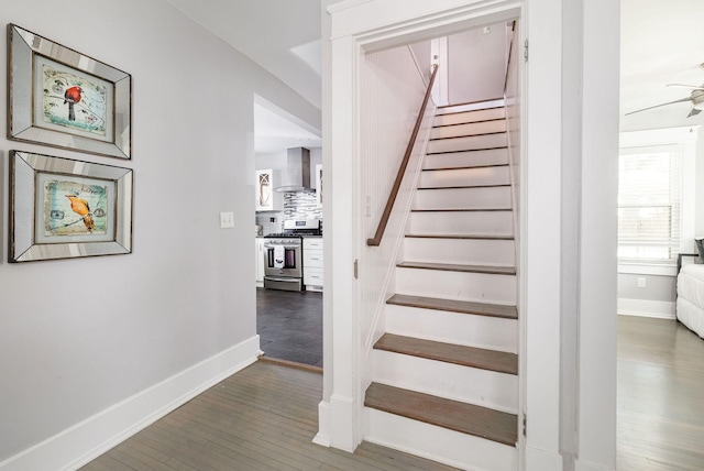 stairs with hardwood / wood-style flooring and ceiling fan