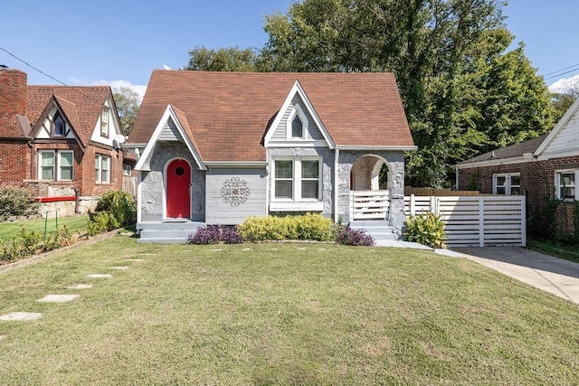 tudor home with a front lawn