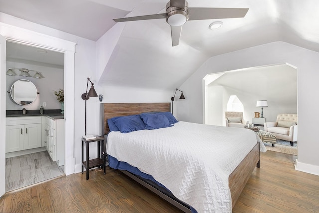 bedroom with ceiling fan, ensuite bathroom, lofted ceiling, and dark wood-type flooring