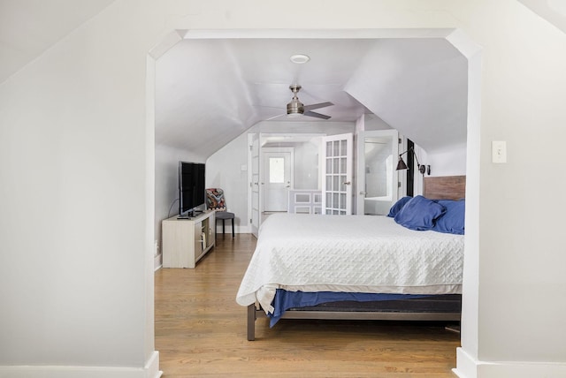 bedroom with ceiling fan, vaulted ceiling, and hardwood / wood-style flooring