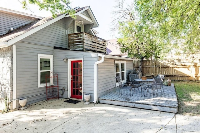 rear view of property with a patio, a balcony, and a wooden deck