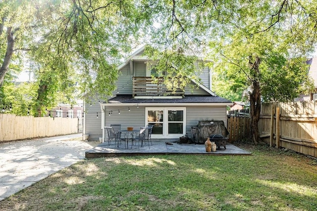 rear view of house with a lawn and a patio