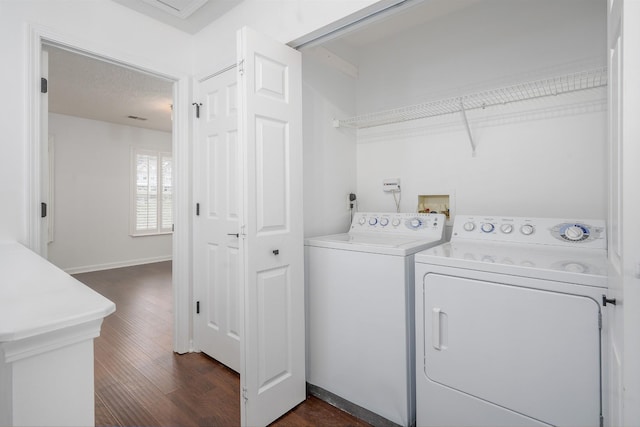 washroom with washer and dryer, a textured ceiling, and dark hardwood / wood-style floors