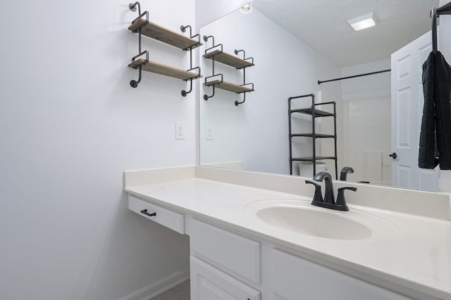 bathroom with vanity, a shower, and a textured ceiling