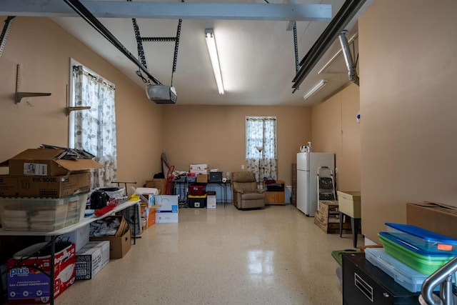 garage featuring white fridge and a garage door opener