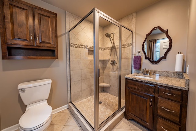 bathroom with toilet, vanity, tile patterned floors, and a shower with door