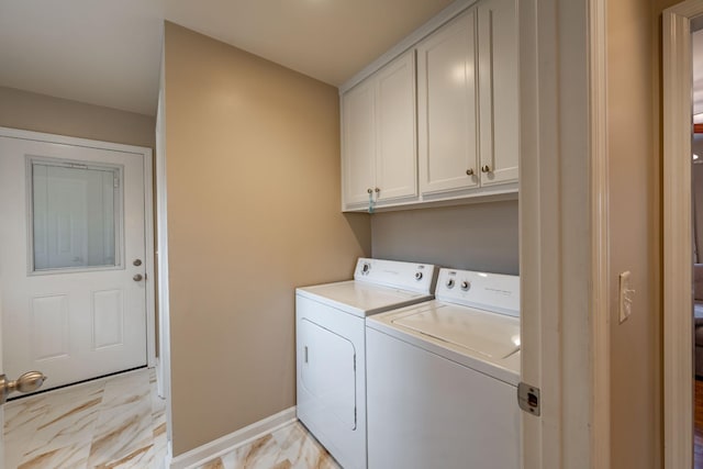 clothes washing area with cabinets and separate washer and dryer