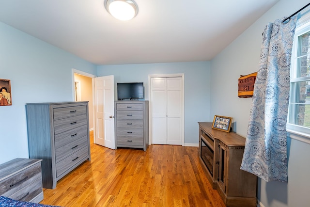 bedroom with light hardwood / wood-style floors and a closet