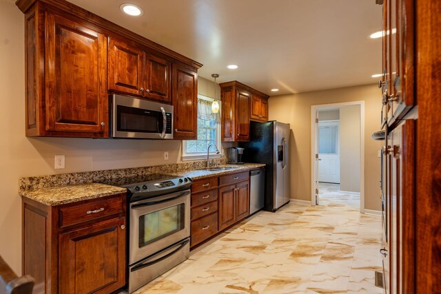 kitchen featuring stone counters, appliances with stainless steel finishes, hanging light fixtures, and sink