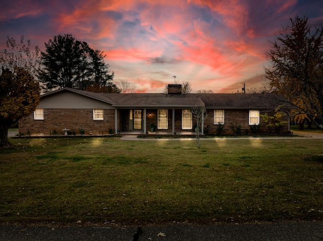 ranch-style home with a yard