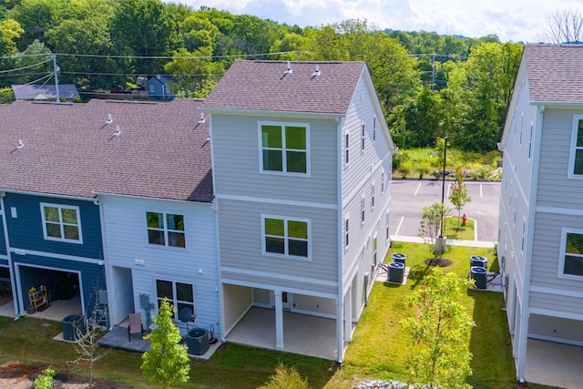 rear view of house featuring cooling unit, a patio area, and a yard