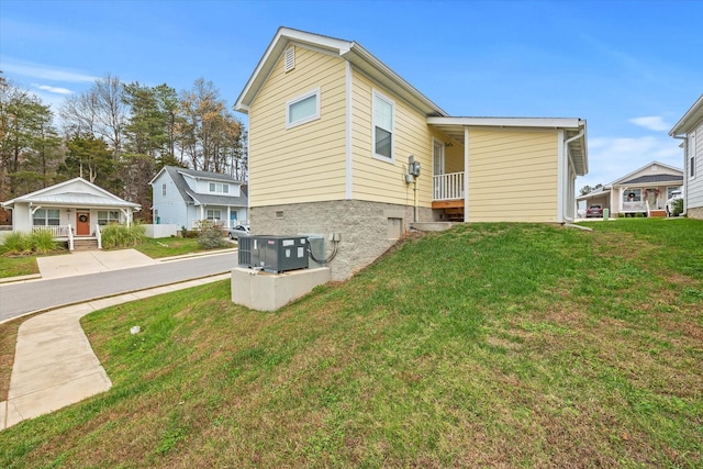 view of side of home featuring a lawn and central AC