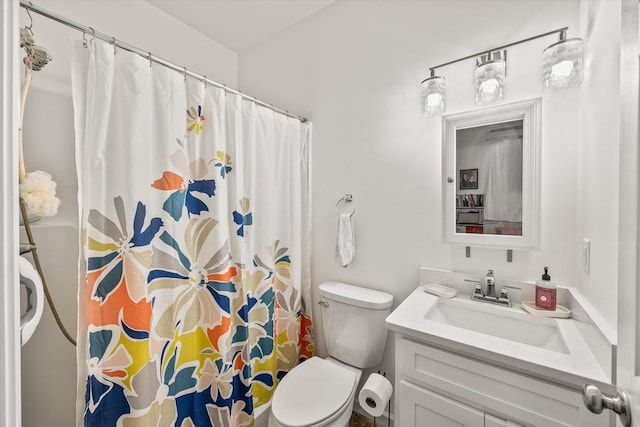 bathroom with curtained shower, vanity, and toilet