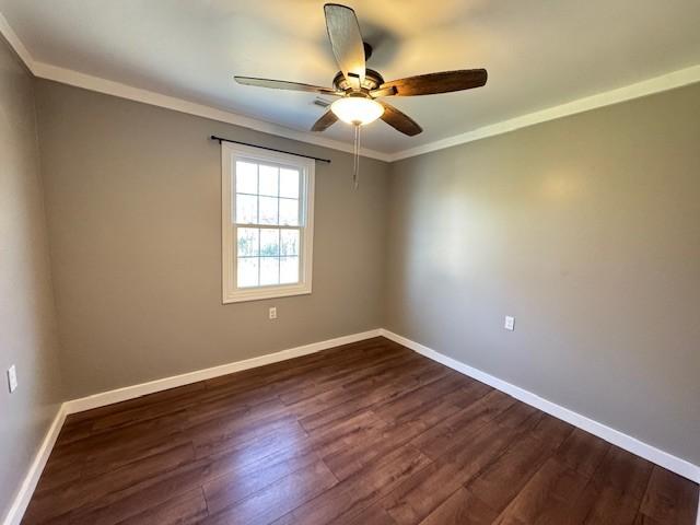 spare room featuring ceiling fan, dark hardwood / wood-style floors, and ornamental molding