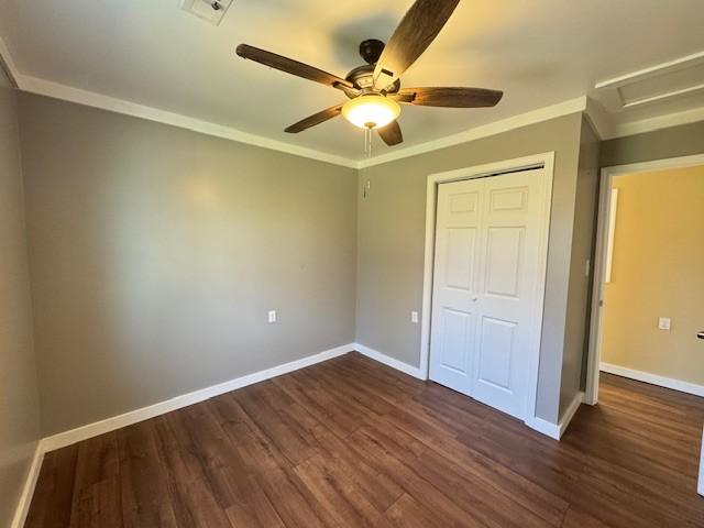 unfurnished bedroom with dark hardwood / wood-style flooring, a closet, and ceiling fan