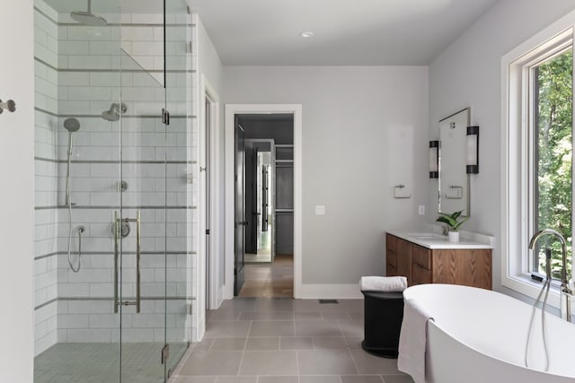 bathroom with tile patterned floors, vanity, and shower with separate bathtub