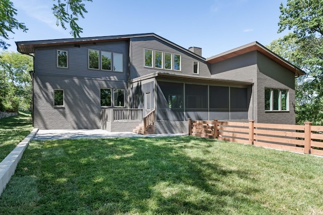 back of property featuring a sunroom and a yard