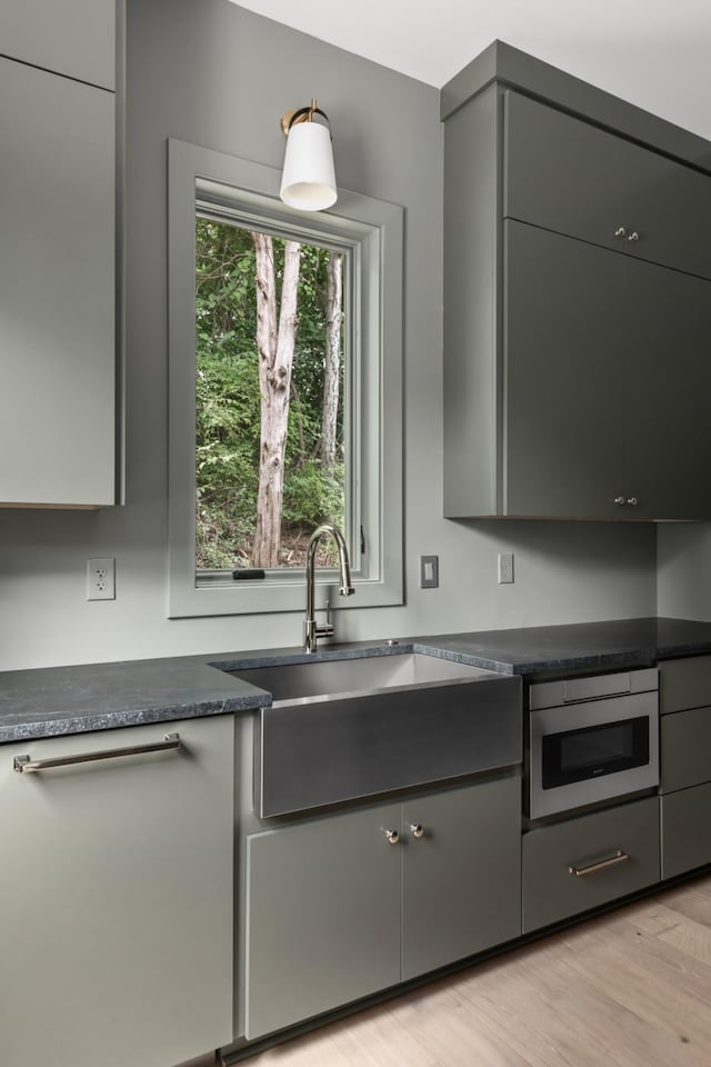 kitchen featuring gray cabinetry, light hardwood / wood-style flooring, and sink