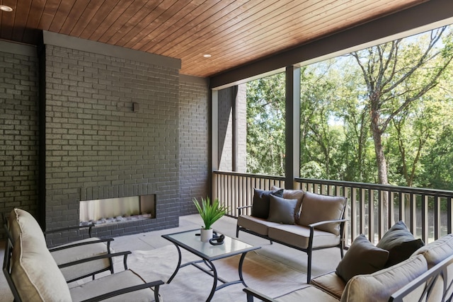 sunroom / solarium featuring a fireplace and wood ceiling