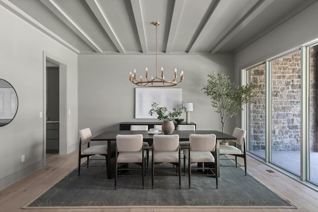 dining room with a chandelier, wood-type flooring, and beam ceiling