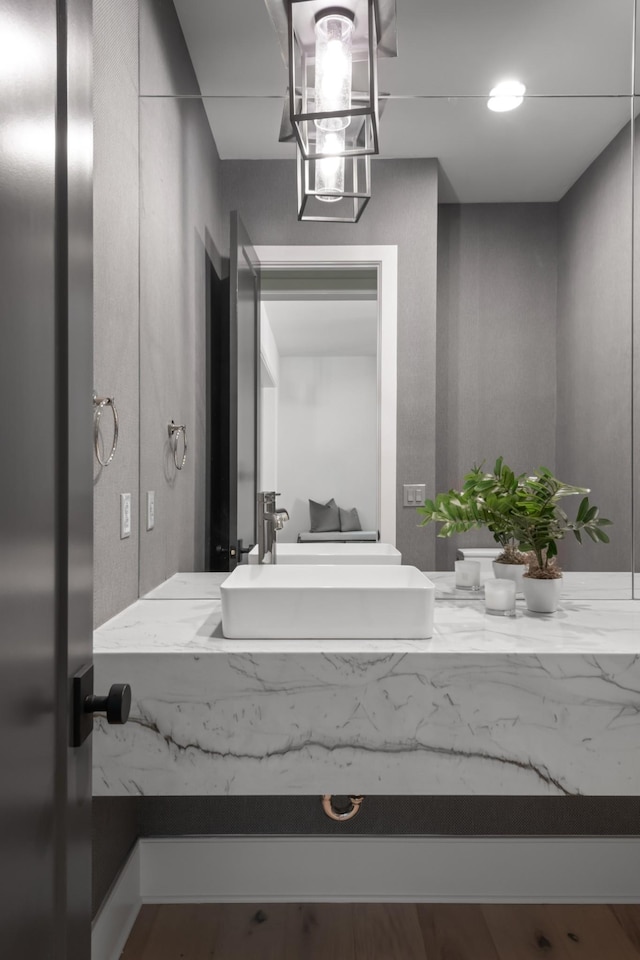 bathroom with a notable chandelier, vanity, and wood-type flooring