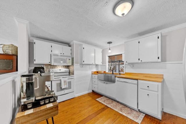 kitchen featuring white cabinetry, sink, light hardwood / wood-style flooring, a textured ceiling, and white appliances