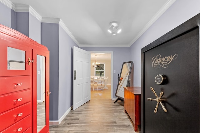 corridor featuring a chandelier, crown molding, and light hardwood / wood-style floors