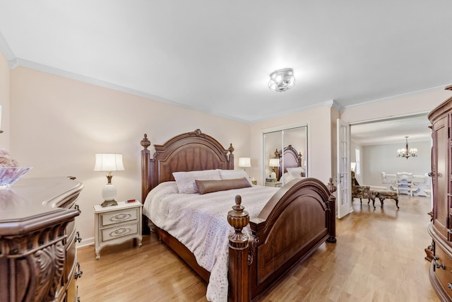 bedroom with french doors, crown molding, a notable chandelier, light hardwood / wood-style floors, and a closet