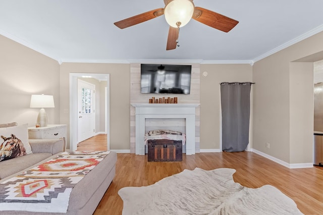 bedroom featuring a fireplace, light wood-type flooring, ceiling fan, and crown molding