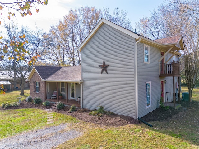 view of side of home with a lawn and covered porch