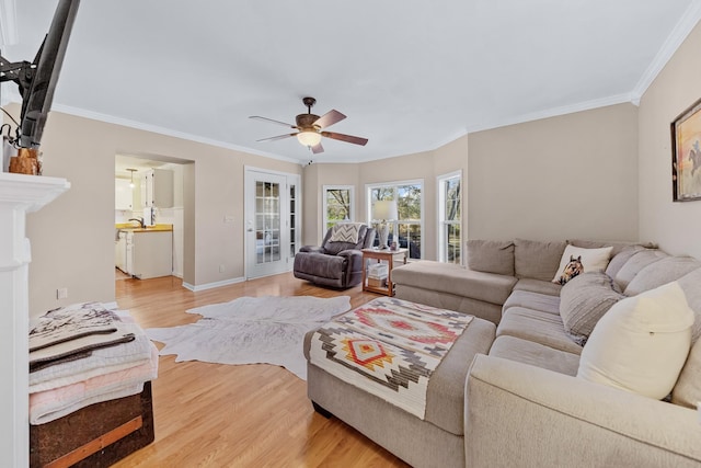 living room featuring ceiling fan, crown molding, and light hardwood / wood-style flooring