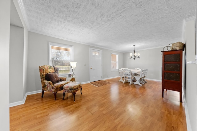 interior space featuring light hardwood / wood-style flooring, an inviting chandelier, a textured ceiling, and ornamental molding