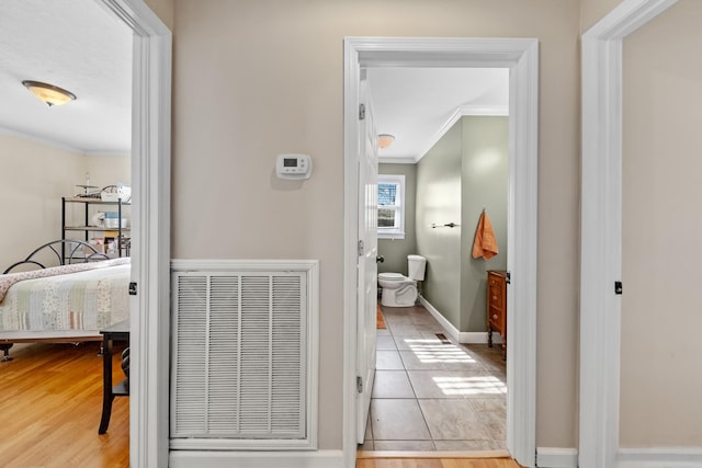 bathroom with wood-type flooring, toilet, and ornamental molding