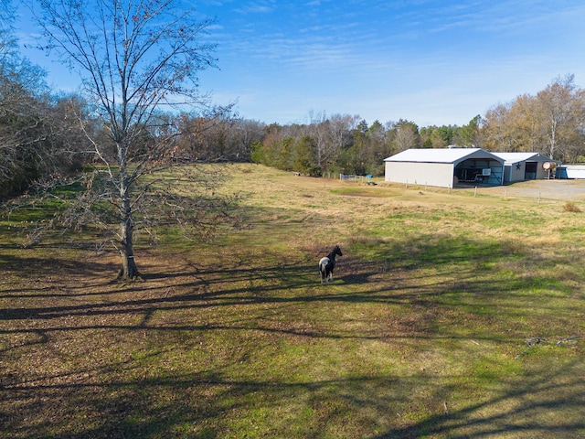 view of yard with an outbuilding and a rural view