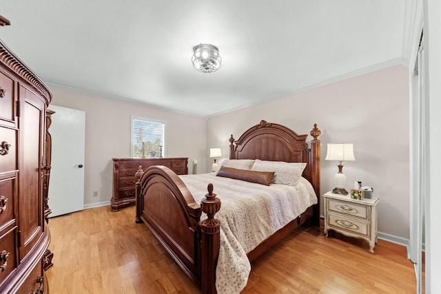 bedroom featuring crown molding and light hardwood / wood-style flooring