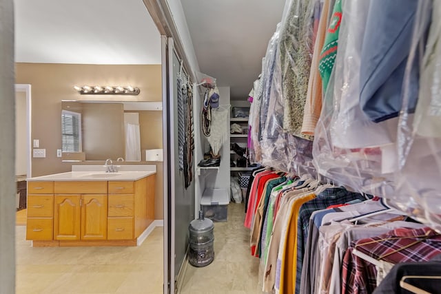 spacious closet with light tile patterned floors and sink