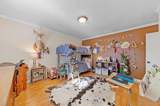 bedroom featuring a textured ceiling, light hardwood / wood-style floors, and crown molding