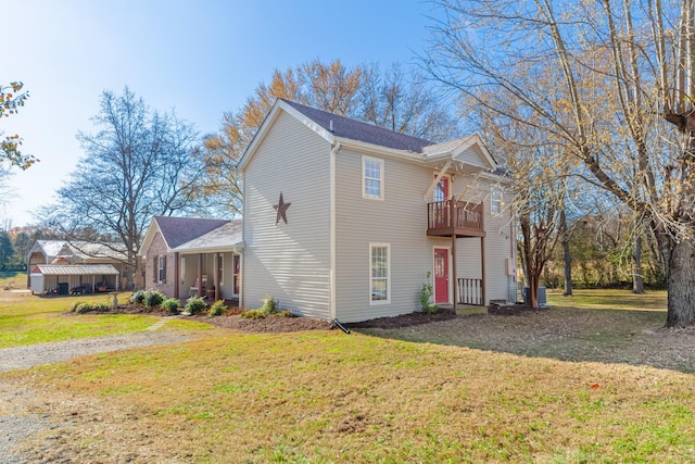 view of front of property with a balcony and a front yard