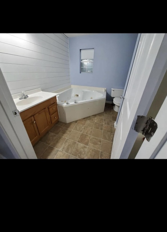 bathroom featuring a bath, toilet, tile patterned floors, and sink